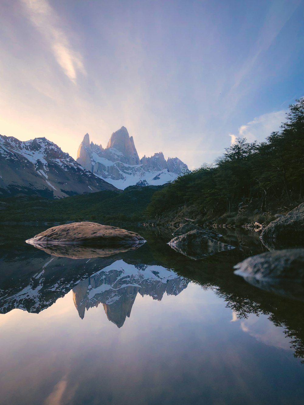 Las montañas se reflejan en el agua quieta del lago