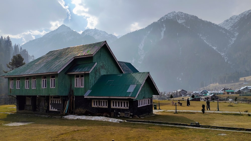 a green house with a mountain in the background