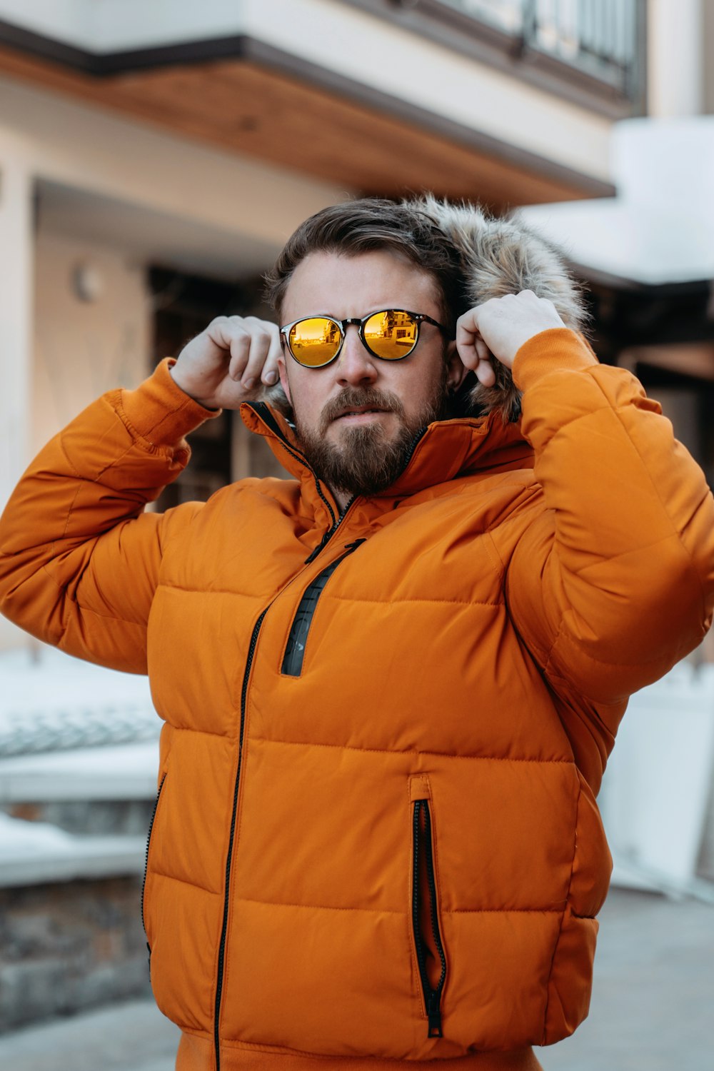 um homem em uma jaqueta laranja e óculos de sol
