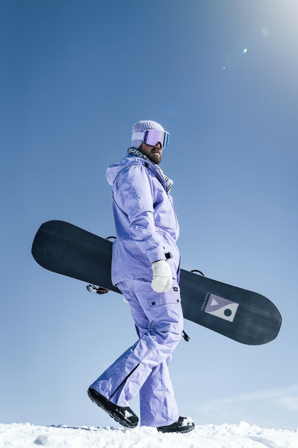 a man walking in the snow with a snowboard