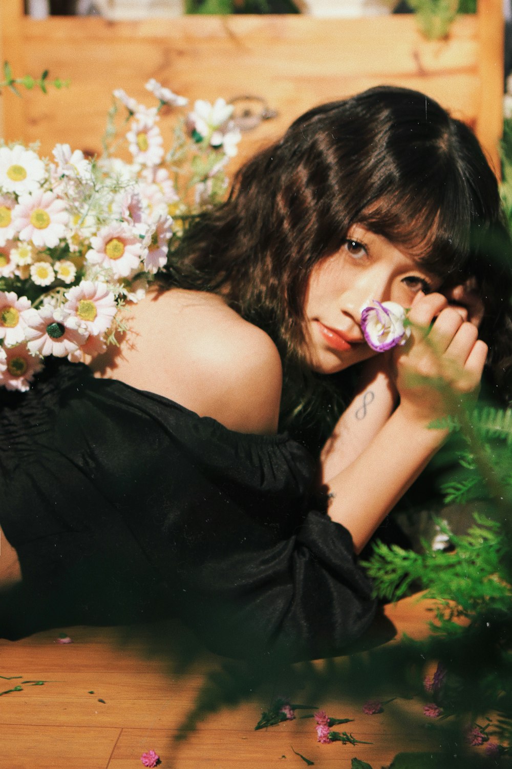 a woman laying on the ground next to flowers