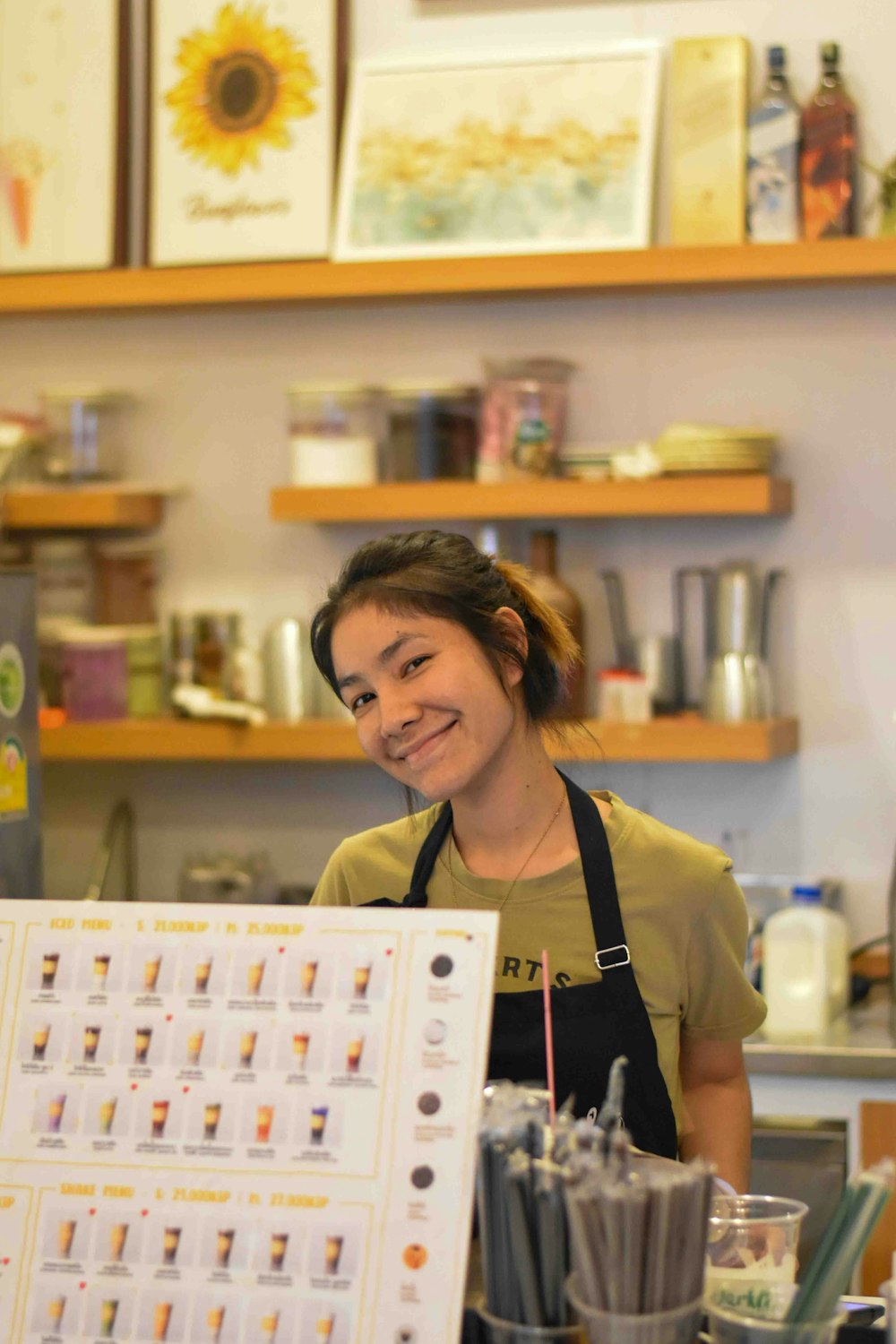 a woman behind a counter with a menu in front of her