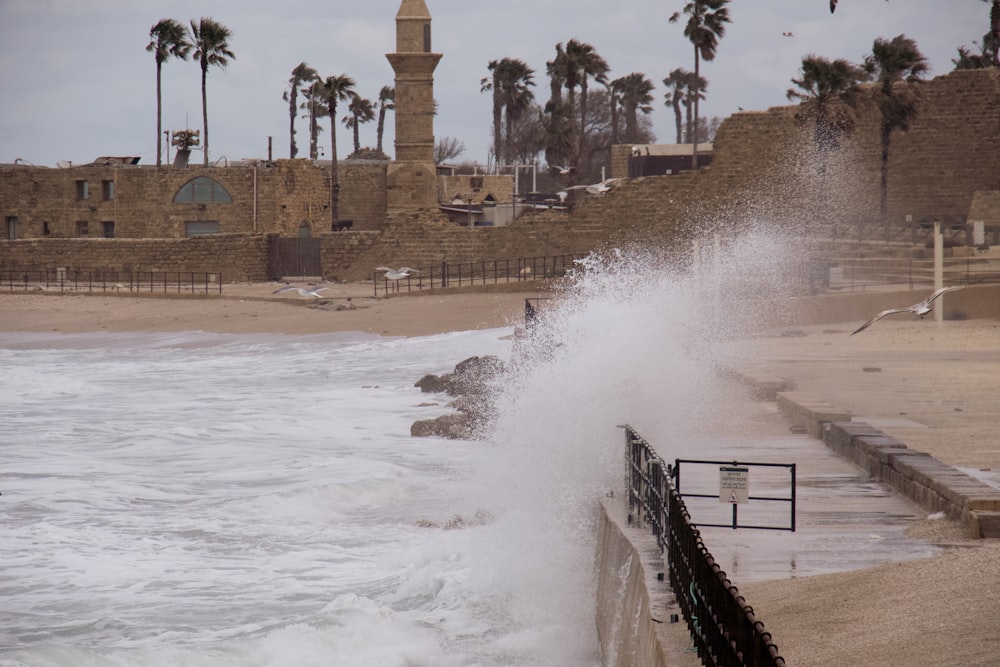 a large wave crashing into the shore of a beach