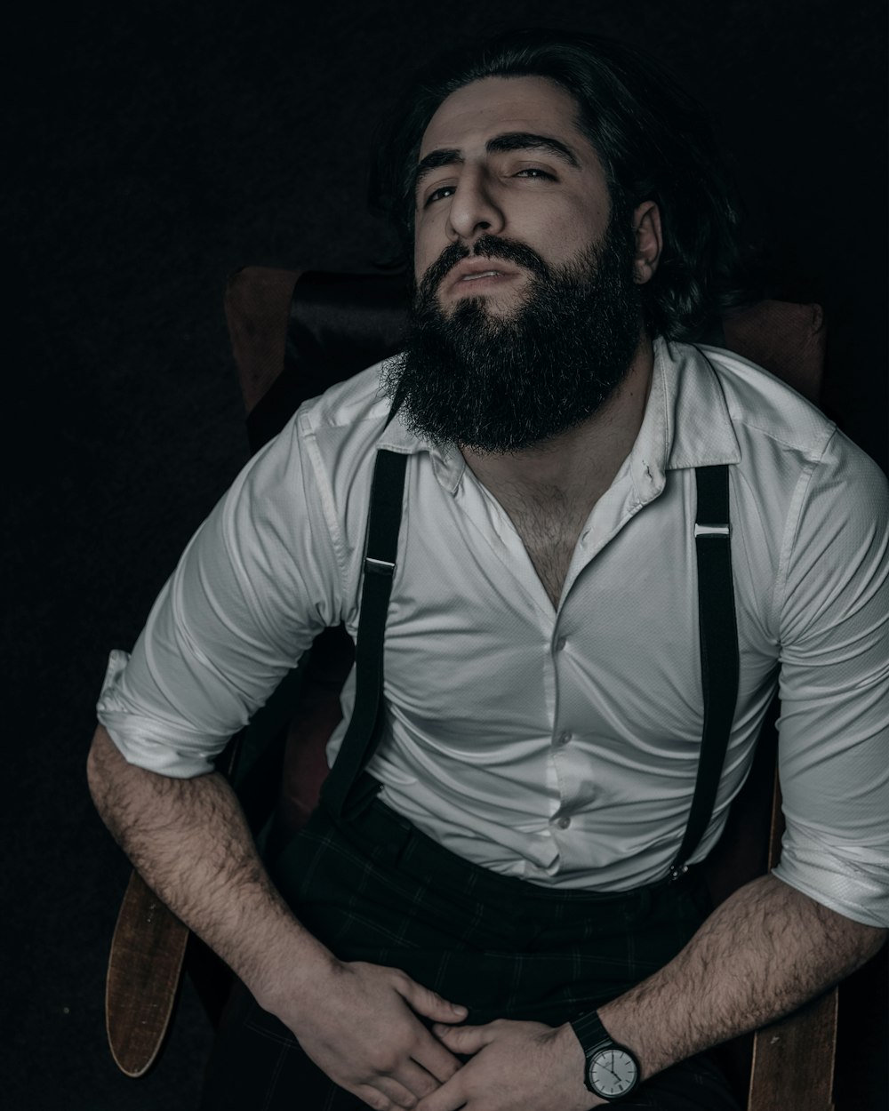 a man with a beard sitting in a chair