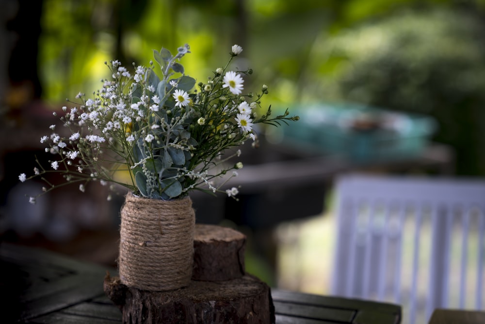 a vase filled with white flowers sitting on top of a wooden table