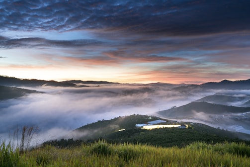 A sweeping landscape shot capturing the vastness of a misty mountain range at dawn.