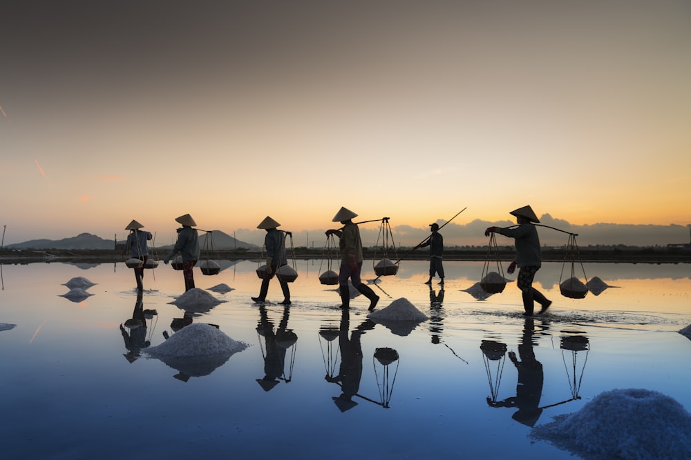 a group of people walking across a body of water