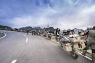 A group of riders pausing at a scenic overlook with misty mountains stretching into the distance.