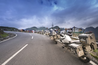 A group of motorcycles lined up on a winding road.