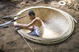 A group of locals weaving traditional Breton baskets outdoors.