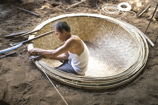A group of locals weaving traditional Breton baskets outdoors.