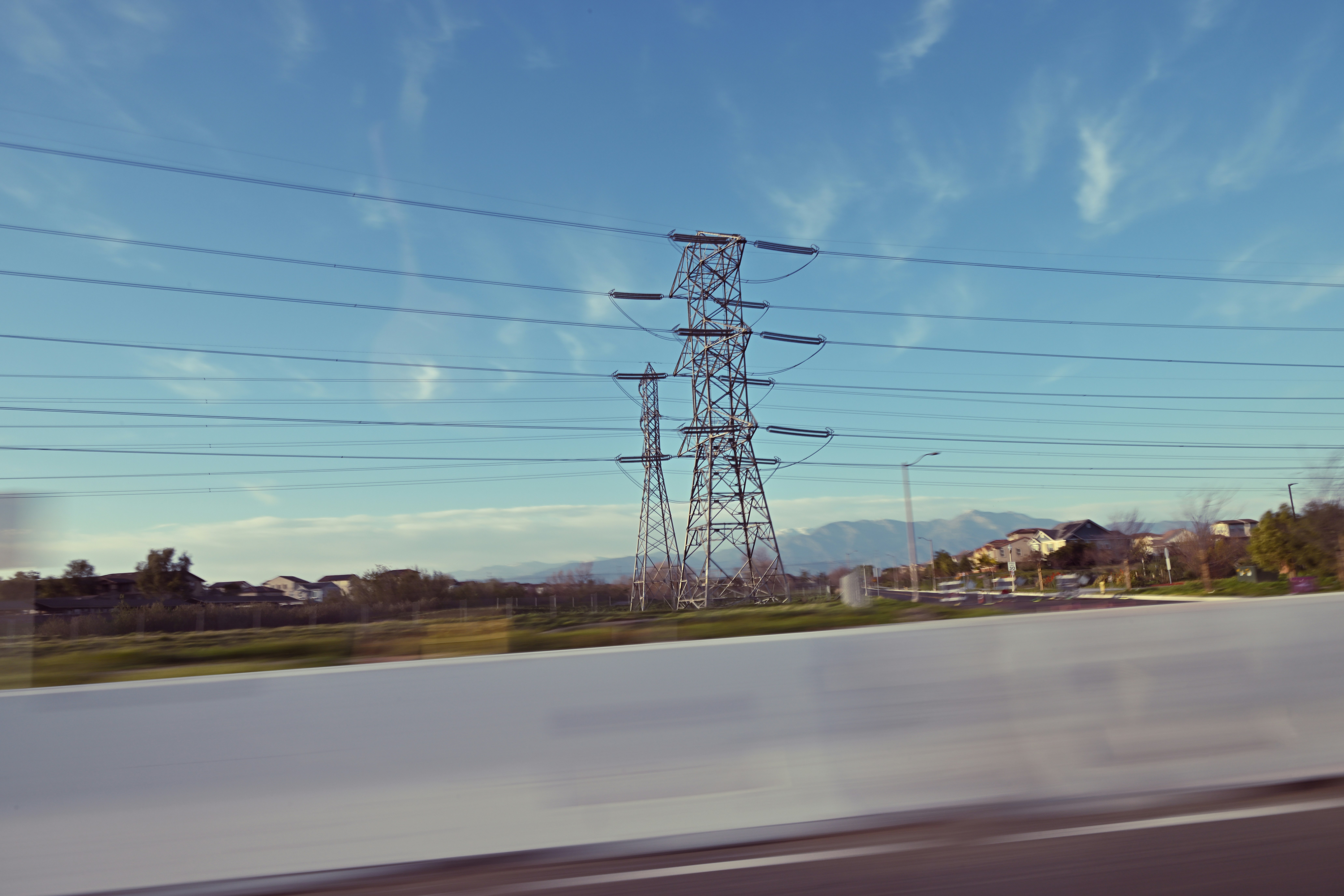 Electric SUV driving on an open highway, representing a Tesla Model X road trip