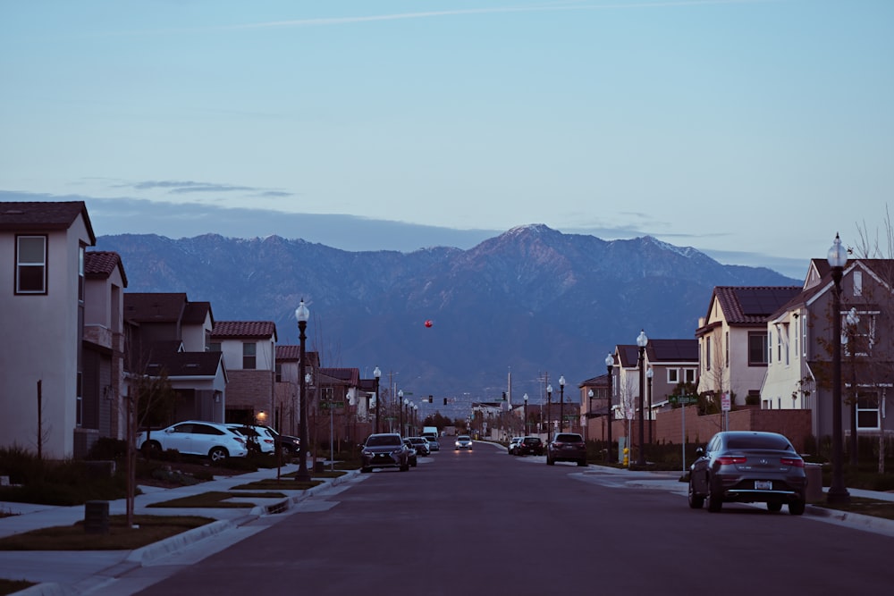 a street lined with houses with mountains in the background