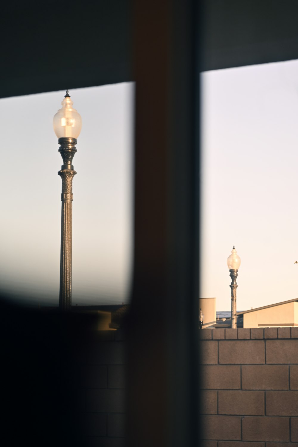 a street light sitting next to a brick wall