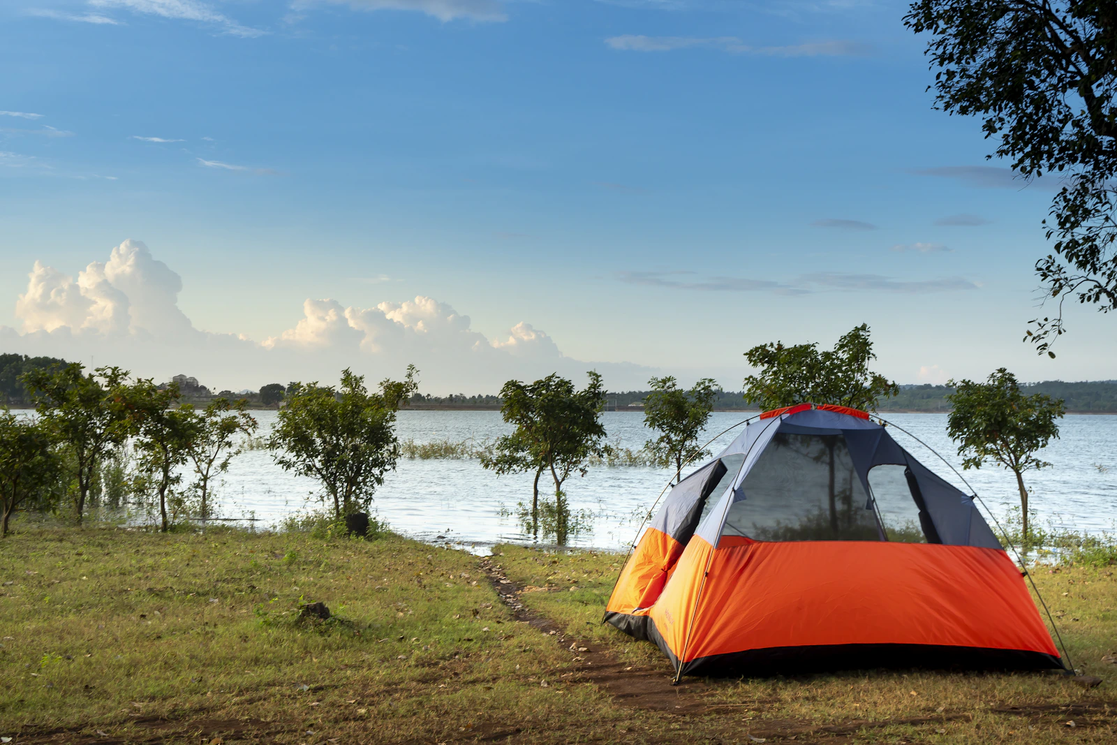 Camping tent beside a lake in an outdoor setting