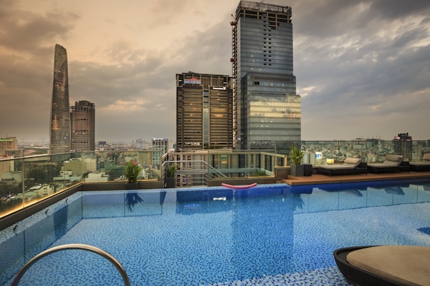 A luxurious hotel infinity pool overlooking the iconic Dubai skyline at dusk with shimmering lights.