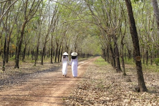 The couple holding hands on a sunlit riverside path in Vietnam