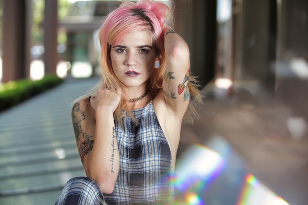 a woman with pink hair sitting on a bench