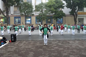 a group of people in green shirts and white pants
