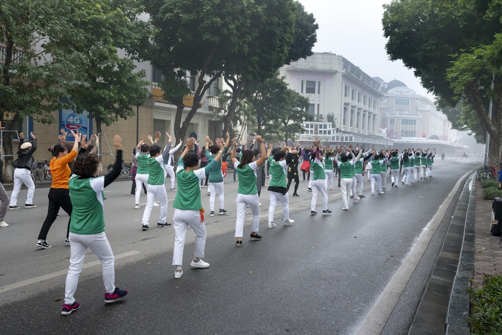 a group of people in green and white outfits marching down a street