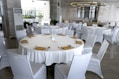 a table with white chairs and gold place settings