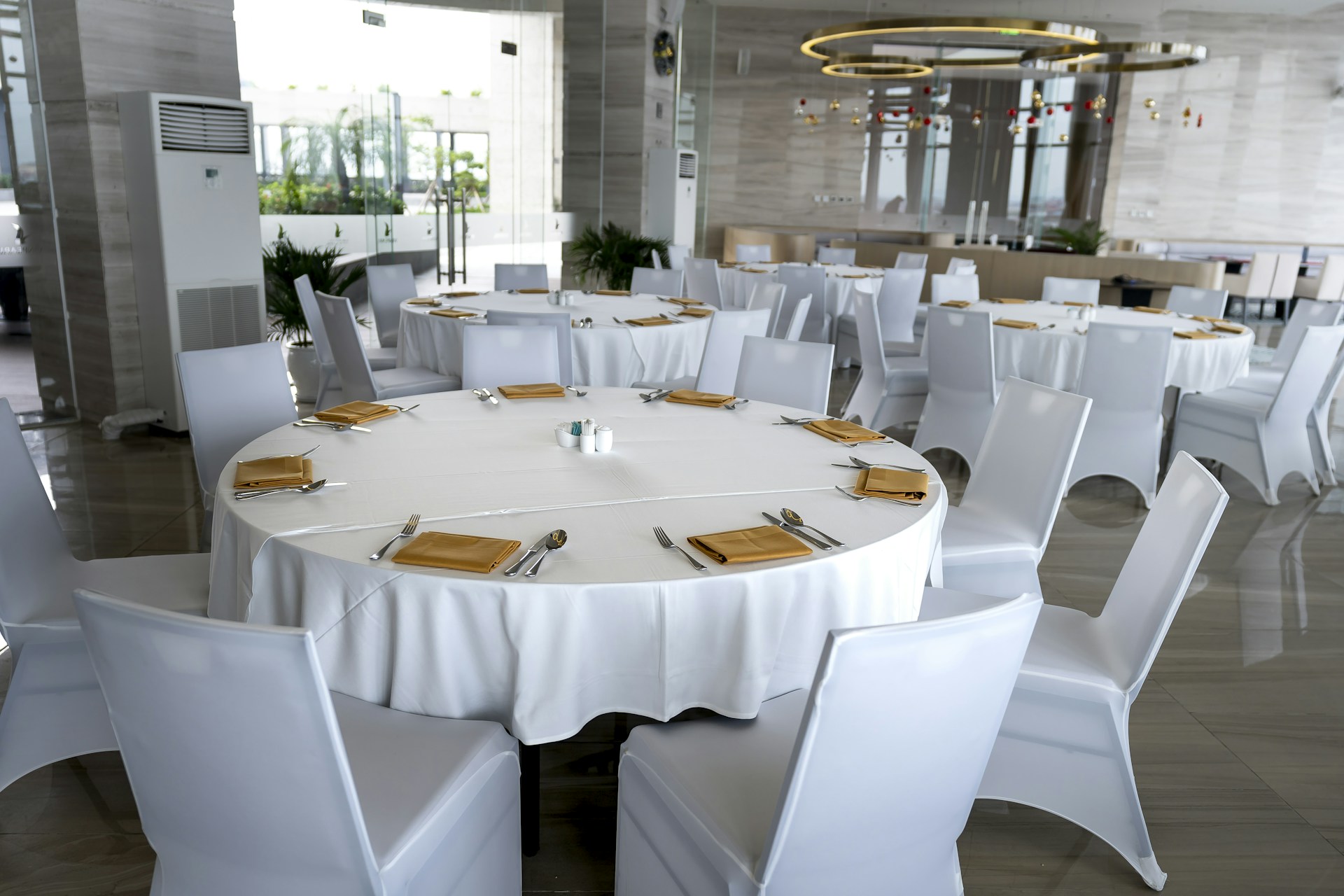 a table with white chairs and gold place settings