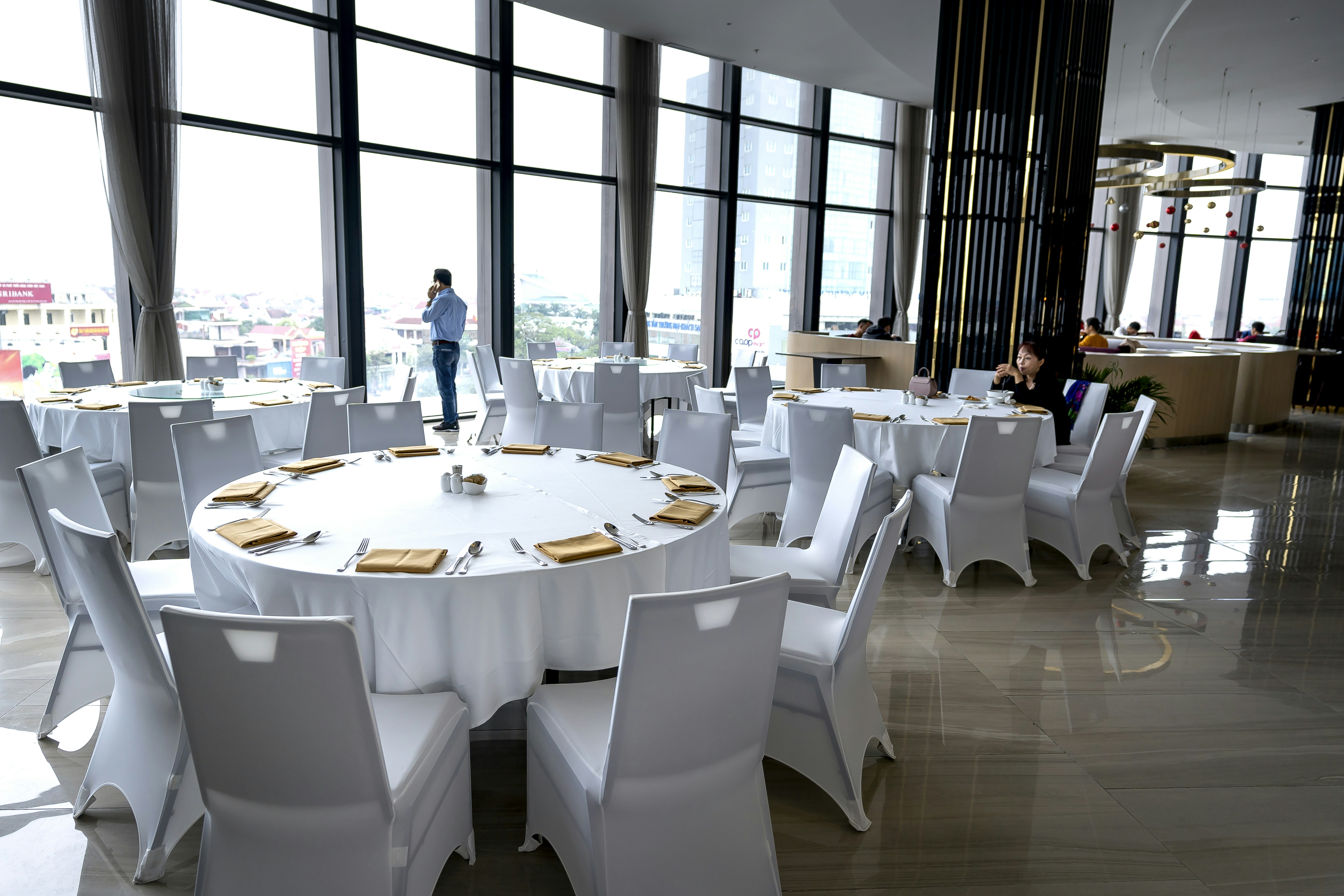 a room filled with lots of white tables and chairs