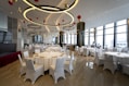 a banquet room with white tables and white chairs