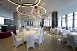 a banquet room with white tables and white chairs