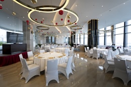 a banquet room with white tables and white chairs