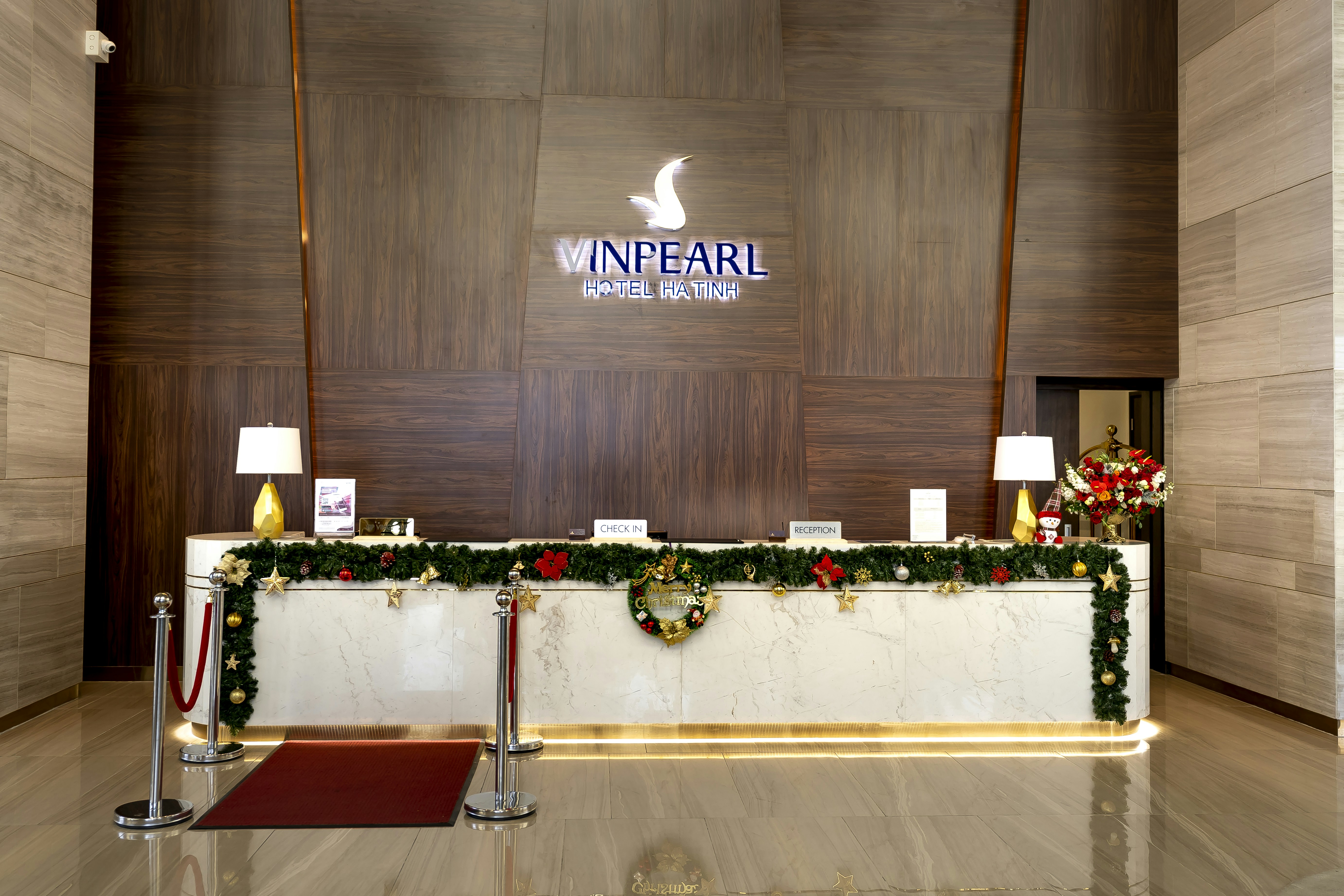 Empty hotel reception desk decorated with Christmas garlands and ornaments.