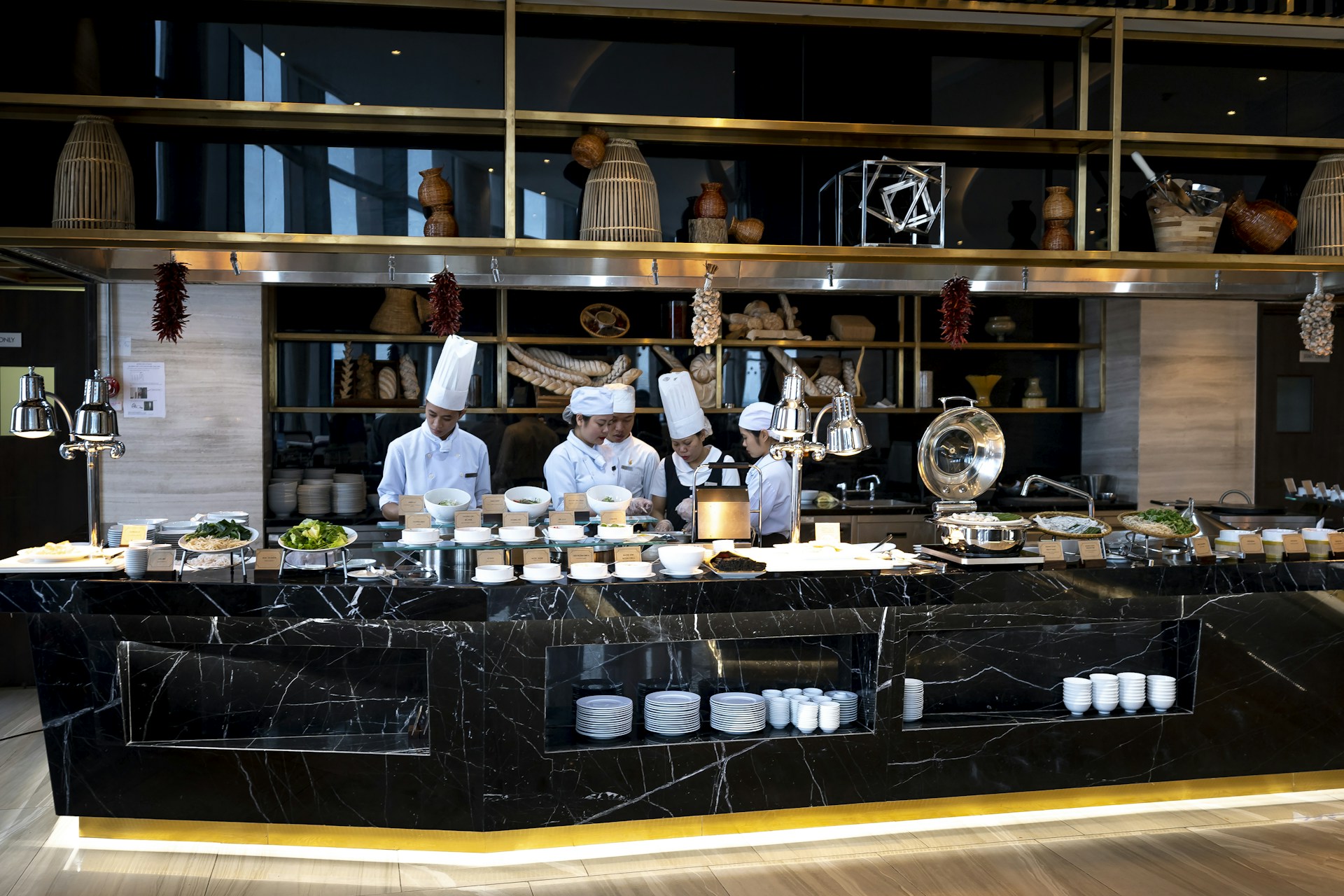 a couple of chefs preparing food in a kitchen
