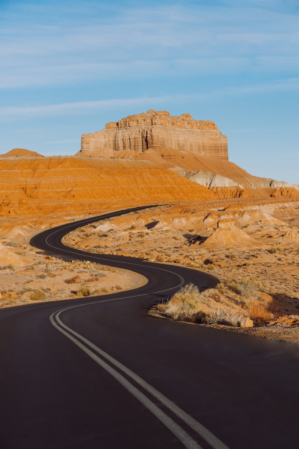 a curved road in the middle of a desert