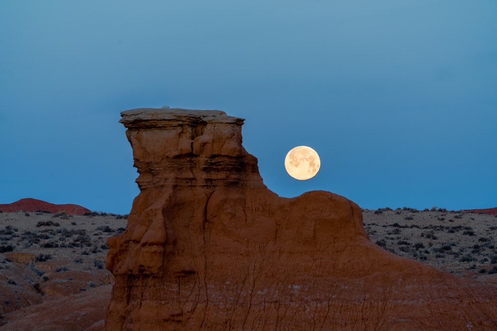 砂漠の風景に満月が昇る