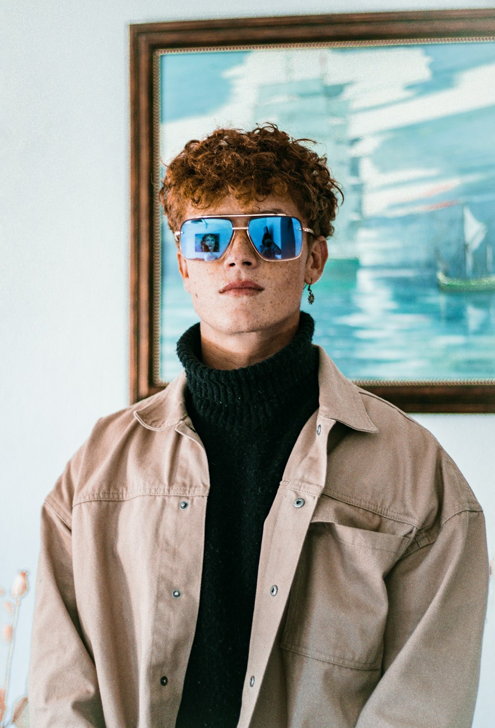 a young man with red hair wearing blue glasses