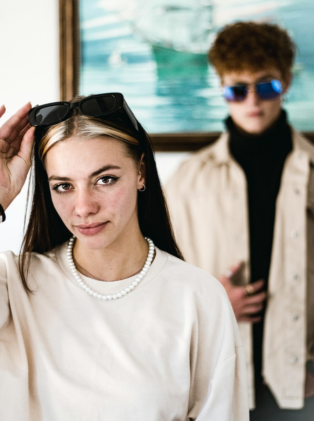 a woman wearing a pearl necklace and sunglasses