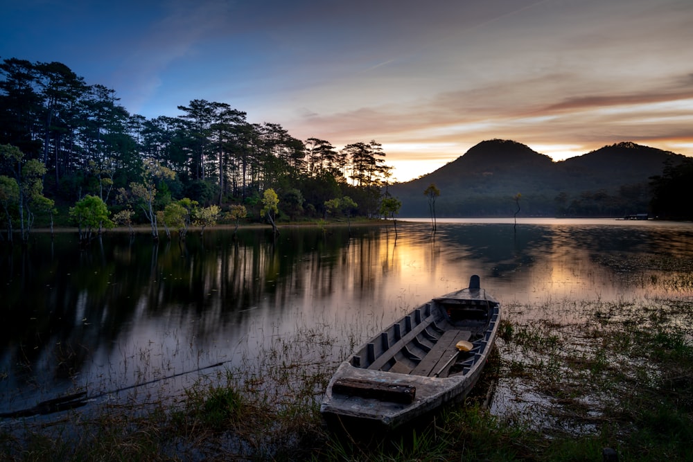 a boat sitting on the shore of a lake