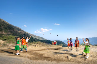 A group of travelers playing traditional rural sports together in a scenic mountain village.