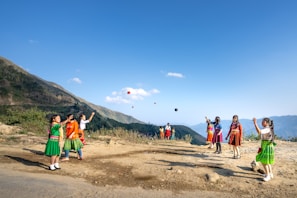 A group of children laughing together while juggling colorful balls.