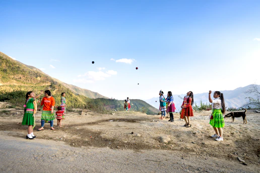 A joyful group of Beninese children playing under a bright blue sky with orange and green accents.