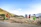 Photo of vibrant tribal children playing together near green fields under blue skies