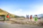 A joyful group of travelers playing traditional sports in a sunny village square.