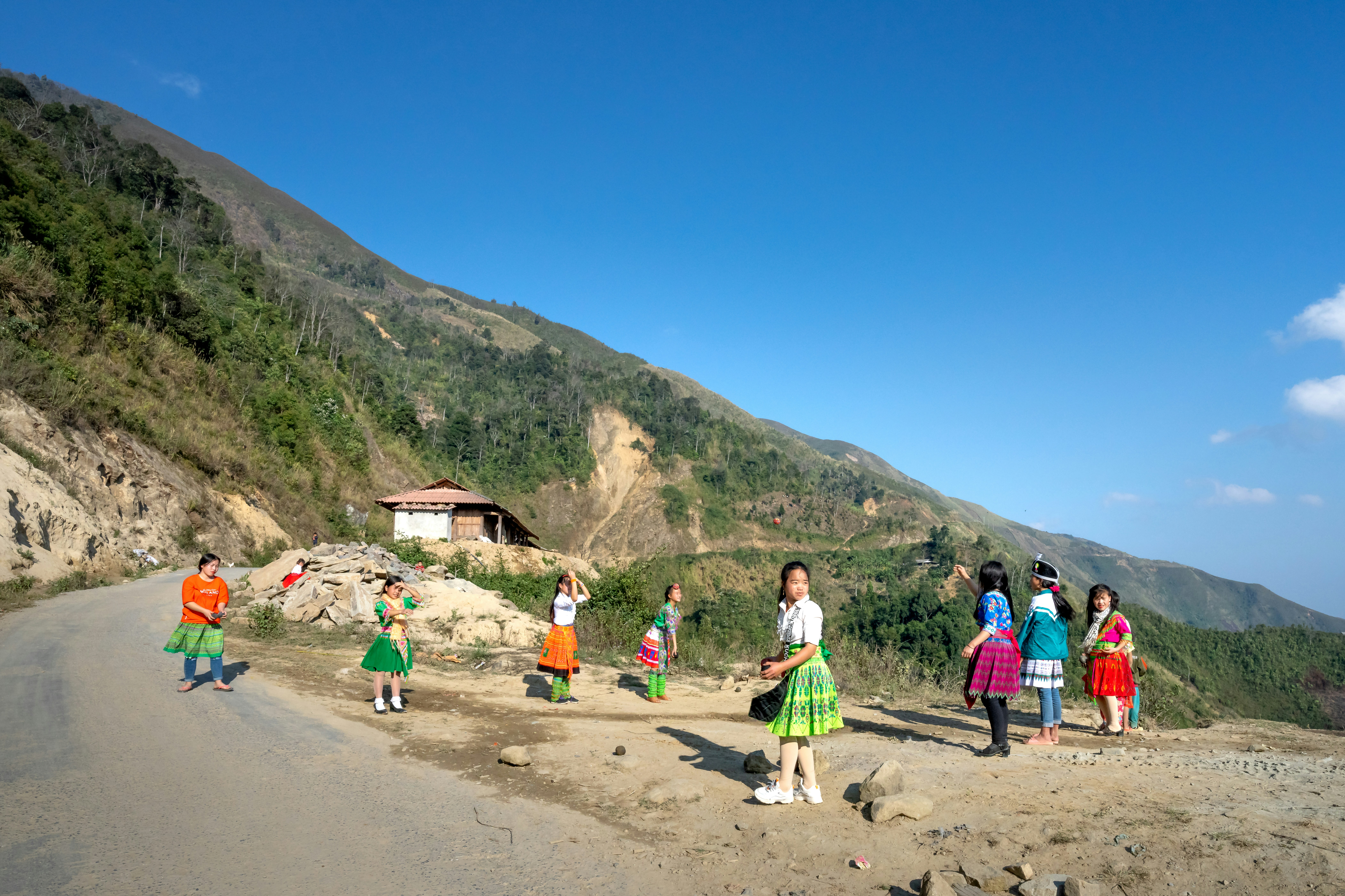 a group of people standing on the side of a road