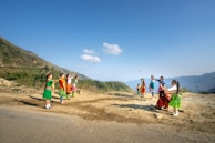 Children playing joyfully in the green fields of the Sacred Valley under a bright blue sky.