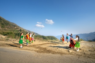 Children playing joyfully in the green fields of the Sacred Valley under a bright blue sky.