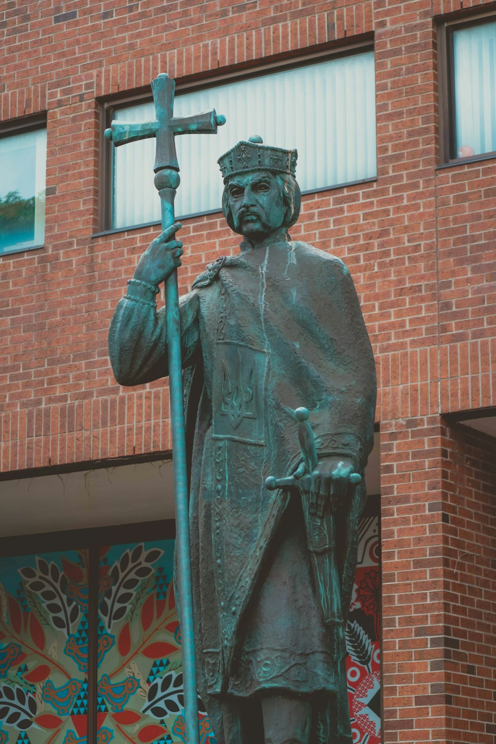 a statue of a man holding a cross in front of a building