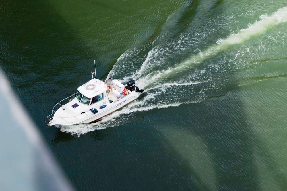 a small white boat traveling across a body of water