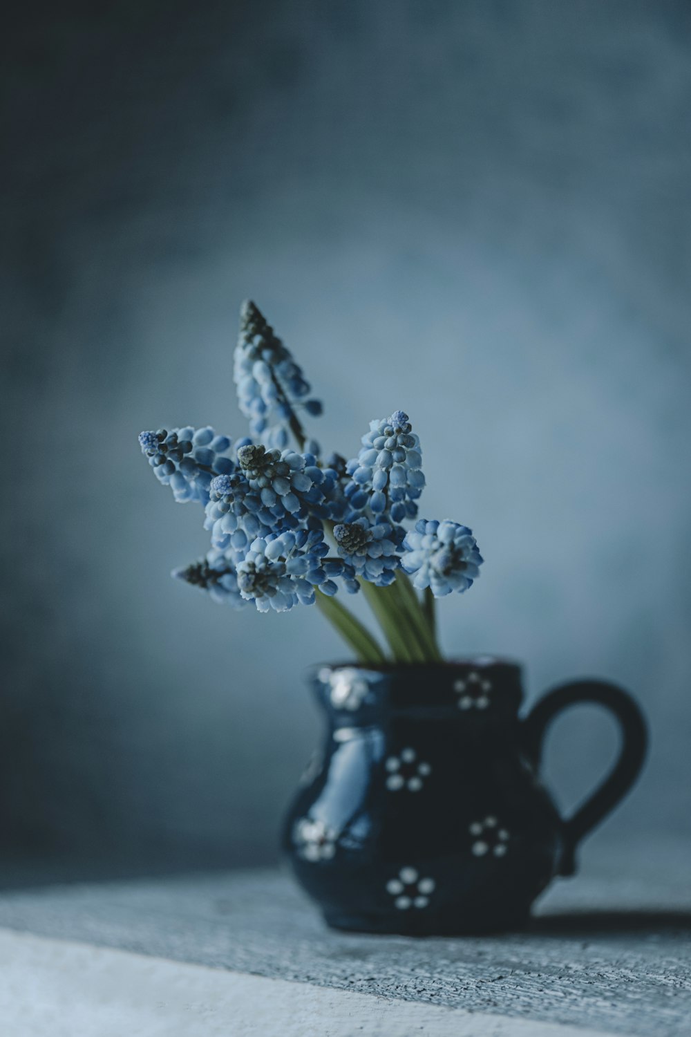 a blue vase filled with flowers on top of a table