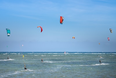 A group of kite surfers gliding smoothly across the flat waters during a downwinder tour.