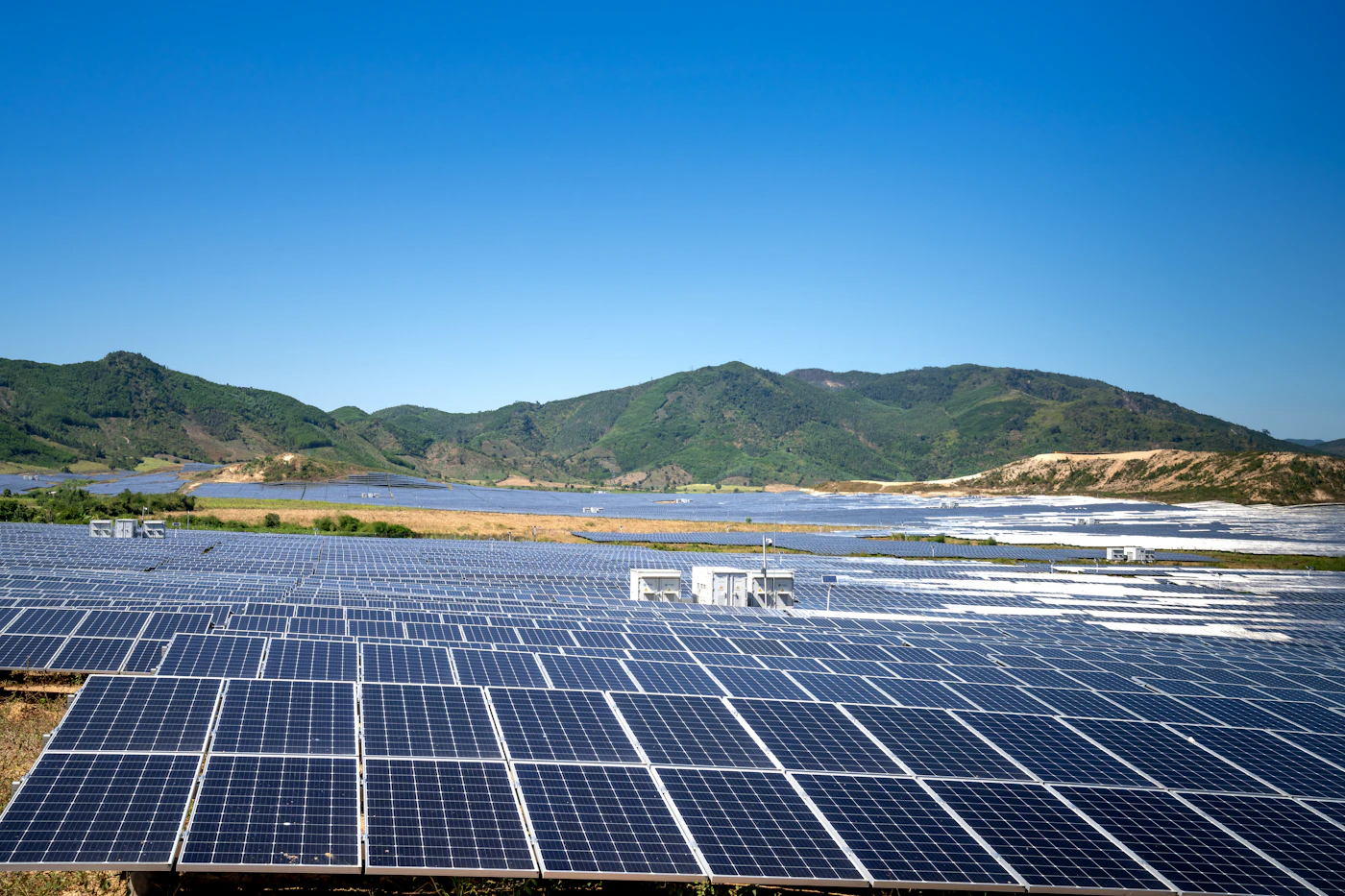 Field of solar panels in front of a mountain ridge